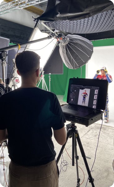 Fotograf przy laptopie podczas sesji w studiu.